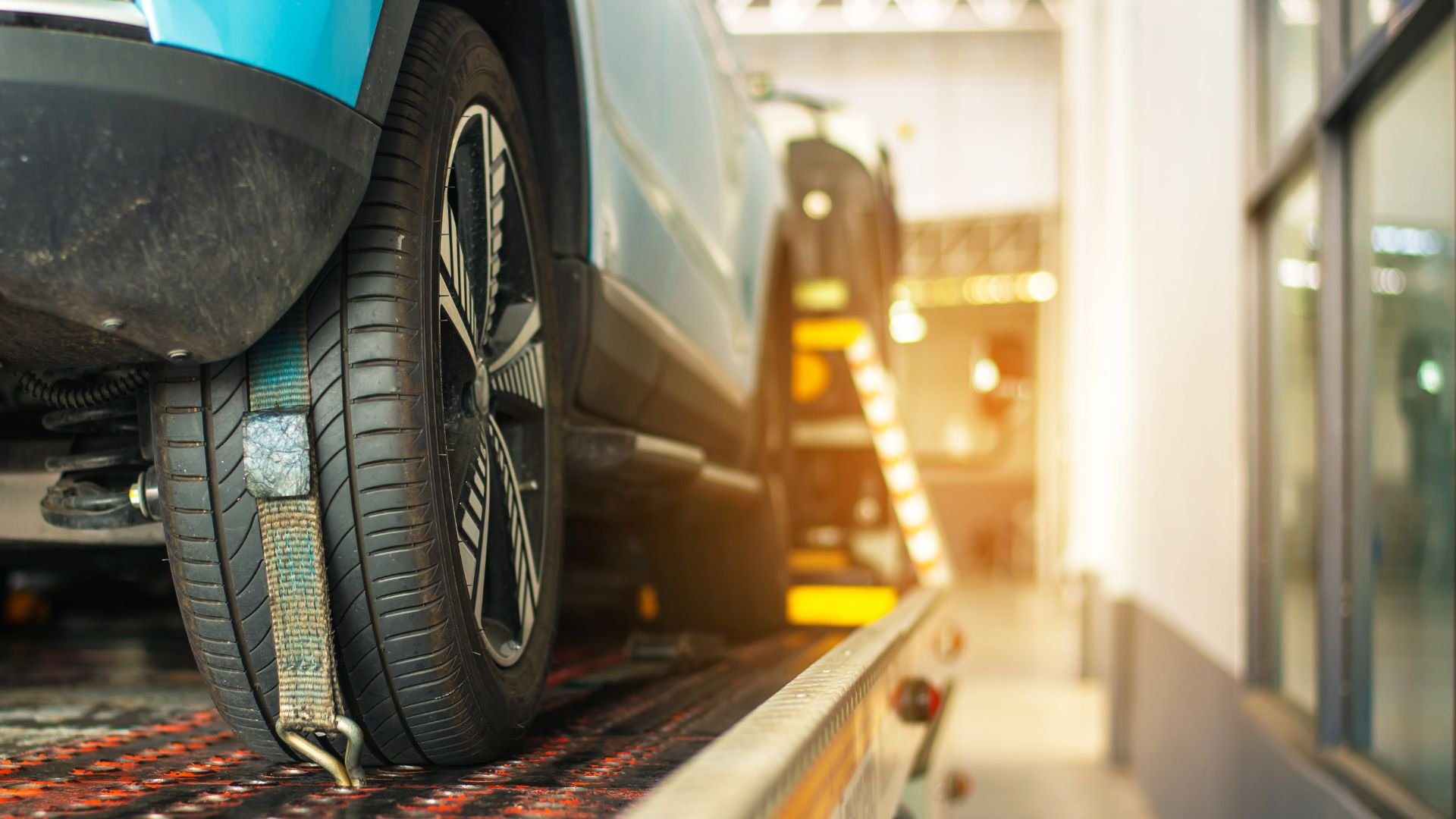 Car tire secured on lift at automotive service center