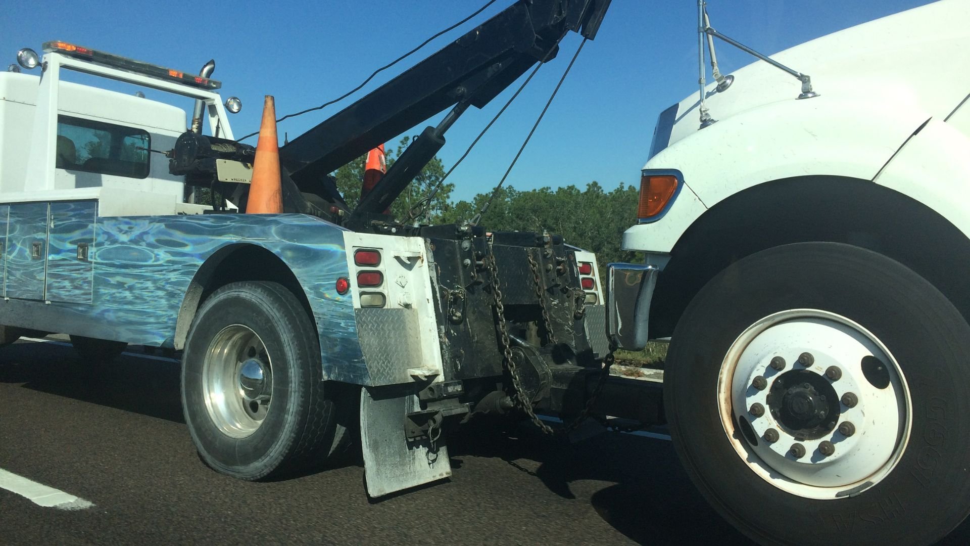 Tow truck with raised crane preparing to move a disabled vehicle